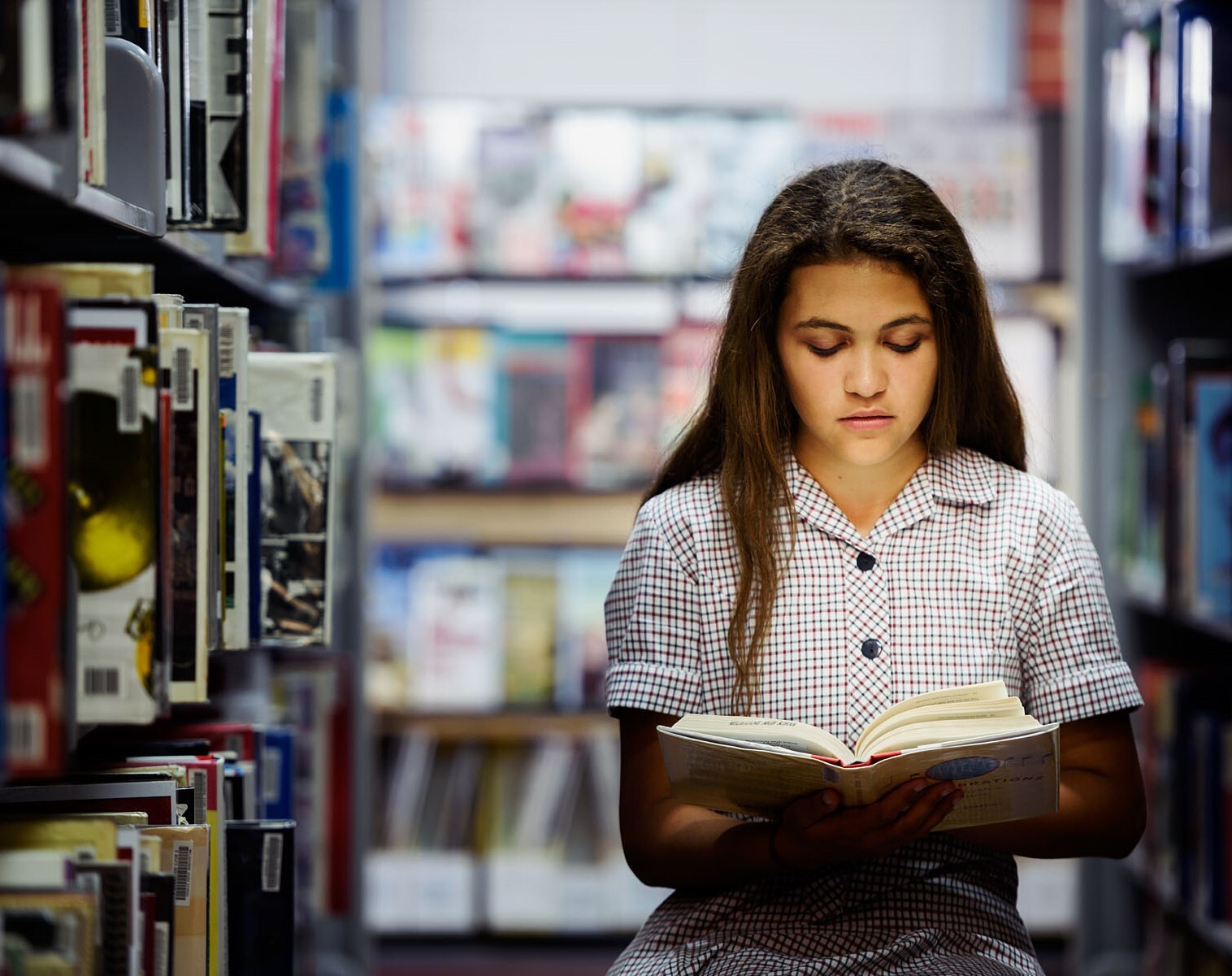 A student reading a book in a library